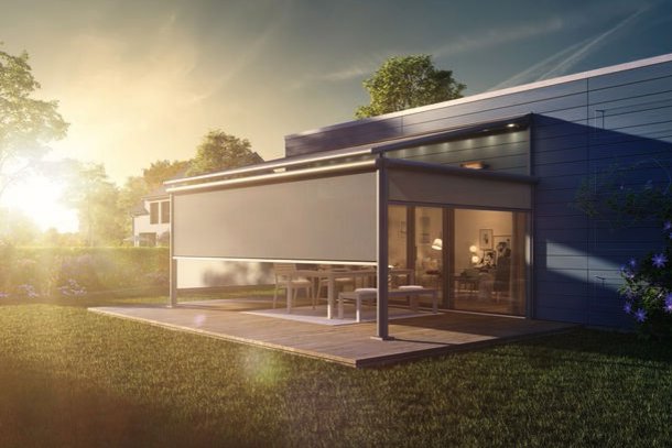 A modern home extension with a glass facade and an outdoor area, set against a sunset. A modern home extension with a glass facade and an outdoor area, set against a sunset.
