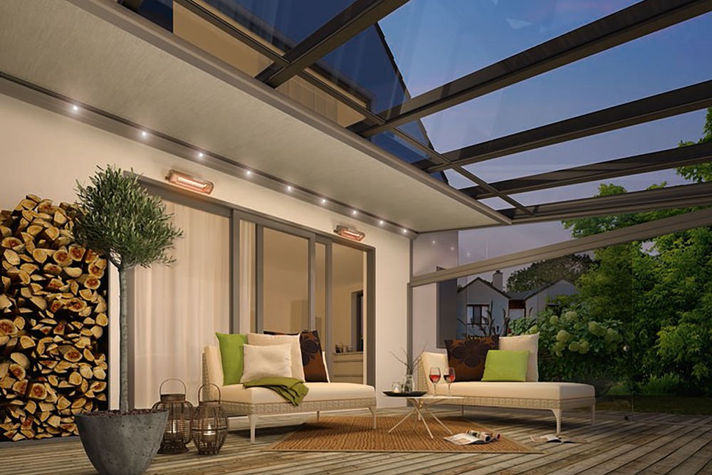 A modern terrace with a glass roof, seating area, and a log stack in a natural setting. A modern terrace with a glass roof, seating area, and a log stack in a natural setting.