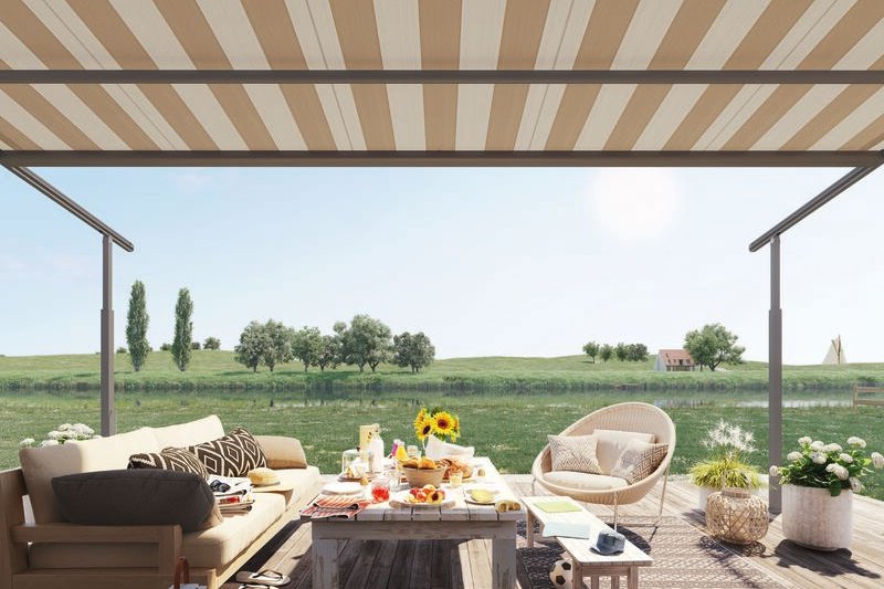 A stylish terrace situation with a striped awning, seating, and a table set for a meal against a green landscape. A stylish terrace situation with a striped awning, seating, and a table set for a meal against a green landscape.