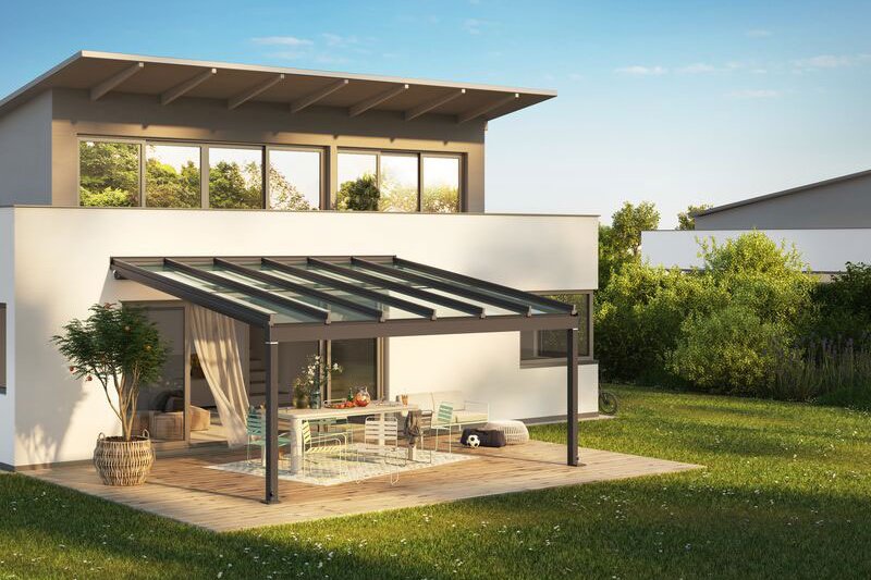 A modern house with a flat roof, featuring a glass-covered terrace and surrounding greenery. A modern house with a flat roof, featuring a glass-covered terrace and surrounding greenery.