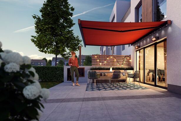 A modern patio with a red awning, greenery, and contemporary architecture in a twilight setting. A modern patio with a red awning, greenery, and contemporary architecture in a twilight setting.