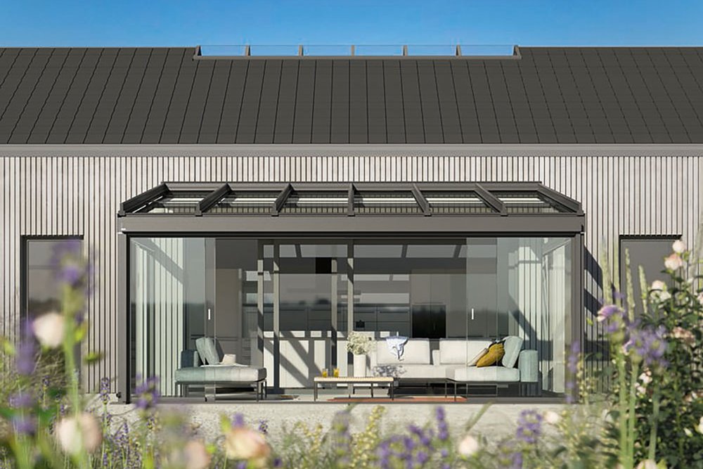Modern house façade with a glass extension and a black roof, set against a clear blue sky. Modern house façade with a glass extension and a black roof, set against a clear blue sky.