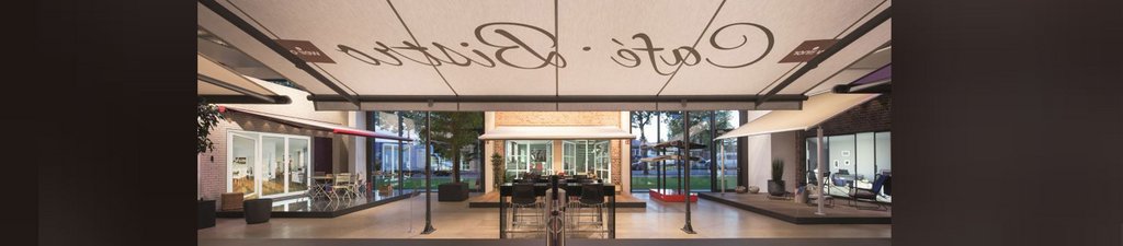 A stylish café entrance featuring a large awning, glass walls, and a modern interior design. A stylish café entrance featuring a large awning, glass walls, and a modern interior design.